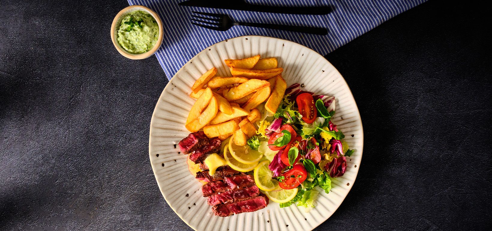 Steak s máslem s nakládaným citronem, zeleným salátem a hranolky s majonézou a zhoug